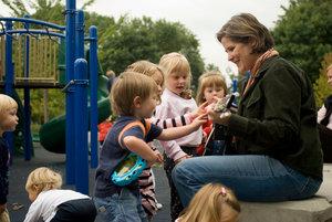 photo of laura with guitar surrounded by children in a park