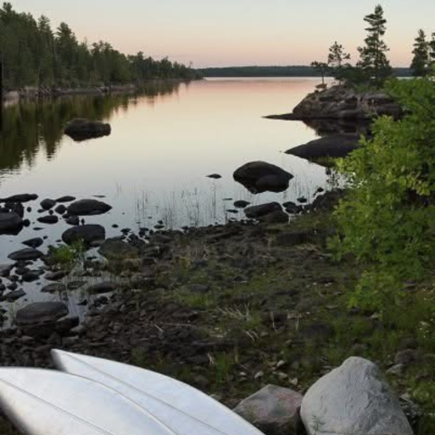 upturned canoe at the edge of a stream